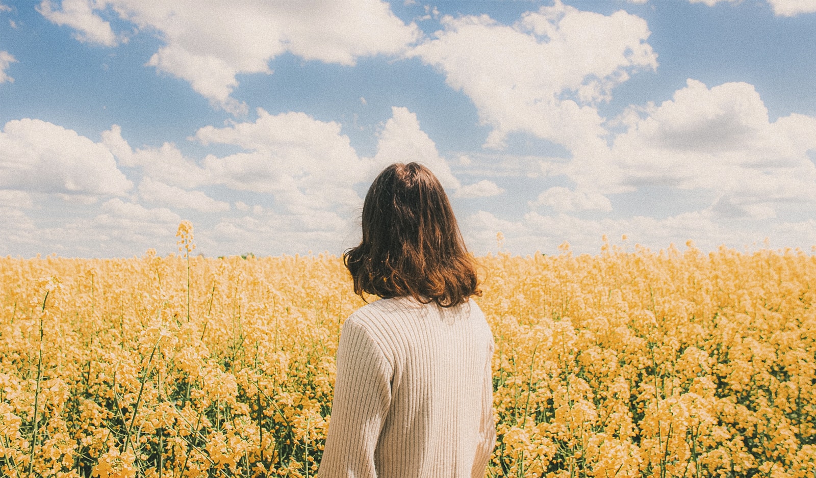 Woman standing in a field of yellow flowers